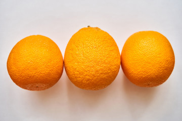 A group of oranges on a table. Three oranges on a white background. Isolate