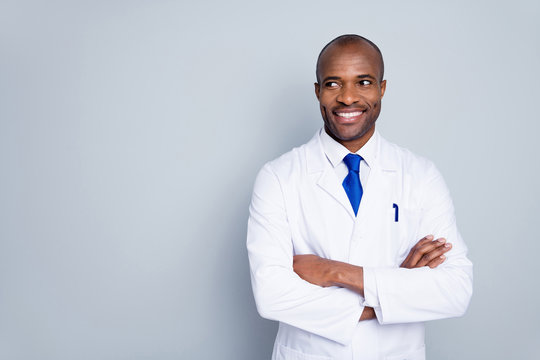 Photo of cheerful dark skin doc guy virologist agent corona virus arms crossed pandemic expert look empty space interested wear white lab coat tie isolated grey color background