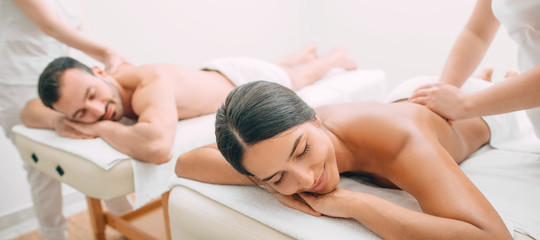 beautiful couple during back massage, joint day at the spa. Man and woman enjoy a massage