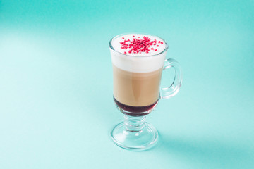 Latte with raspberry berry in a glass transparent glass with a handle