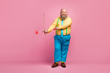 Full length body size view of his he nice funky dreamy glad bearded guy shooting amorous arrows aim goal meeting arrangement isolated over pink pastel color background