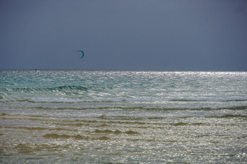 SOTAVENTO LAGOON, FUERTEVENTURA - JANUARY 20, 2020: A kitesurfers are chasing the wind before the storm arrives