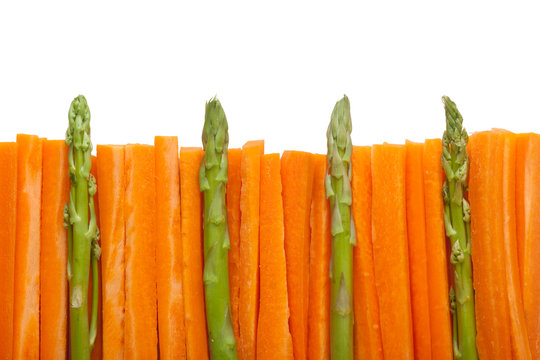 Fence made of carrot sticks and asparagus isolated on white background; 
