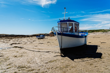 Stranded ships at low tide in the beach. Kervenni in Pointe du Castel Ach. Sunny day of summer - obrazy, fototapety, plakaty