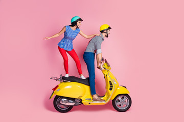 Fototapeta na wymiar Full size profile side photo of careless cheerful wife husband extreme sport motorcyclist ride yellow chopper electric scooter stand look distance road isolated over pastel color background