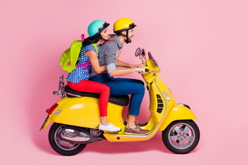 Profile side view of his he her she nice attractive cheerful cheery couple driving moped pastime having fun vacation adventure isolated over pink pastel color background