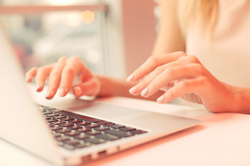 a young girl, female hands are printing on a laptop in a cafe , business woman, 