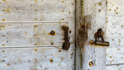 Rustic barn white door and padlock. Wooden planks and locks closeup. Peeling paint and weathered. Space for text. Texture and background.