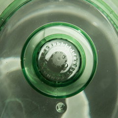 Close-up of a jug with a water purification cartridge. Green. The cartridge shows air bubbles under the water. square
