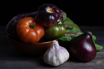 composition with vegetables: red onion, garlic, purple tomato, green tomato and red tomato