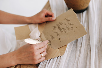 A girl writes a letter with a pen. wedding card, calligraphy. Old letter with vintage handwriting. Romantic love letter.  top view