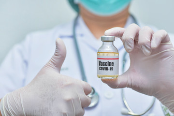 Doctor holding Covid-19 vaccine vial-Medicine and showing thumbs up.-pharmaceutical research and...
