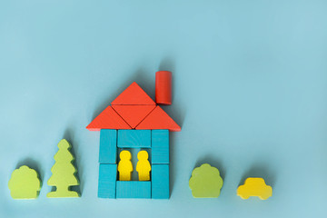 A house made of blocks on a blue background. Flat lay with an inspired quote, staying at home...