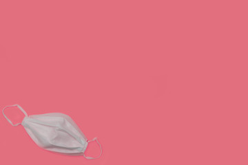Surgical face mask against pink background with large text space