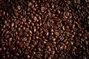 Granos de café extendidos encima de una mesa.