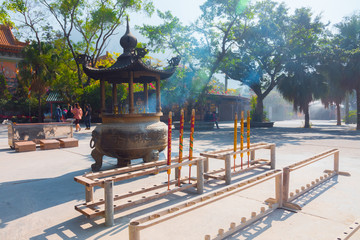 Po Lin Monastery, burning incense (Lantau Island, Hong Kong, China). Burning incense outside of the famous temple. Enormous red and yellow sticks. 