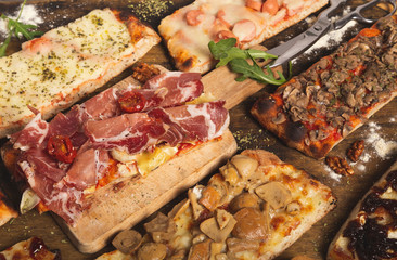 Close up shot of variety of homemade pizza slices. Rectangular portions. Italian food. Assortment of homemade pizzas.