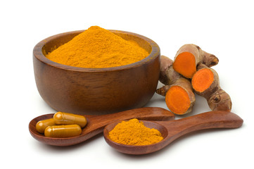 Turmeric (curcumin) powder in   wooden bowl ,capsules and fresh turmeric rhizome isolated on a white background.