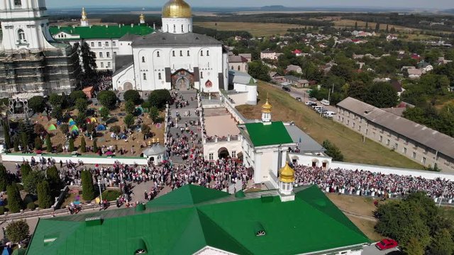 Top view of the Pochaev Lavra at the moment when a lot of people enter it. Orthodox procession in the monastery.