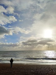 man beach sun clouds