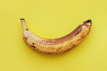 Banana on yellow background, one ripe banana