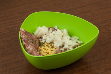 Minced meat in green pot with egg and onion on table.Tasty food