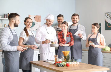 Male chef and group of young people during cooking classes