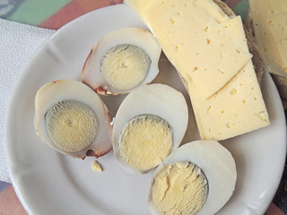 boiled egg in a composition with cheese and mayonnaise on a white plate.