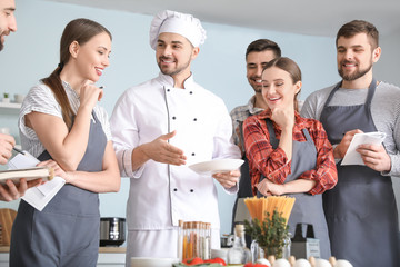 Male chef and group of young people during cooking classes
