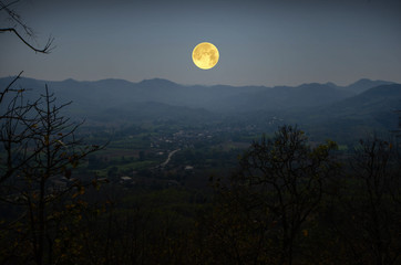 Beautiful super full moon over village in the valley
