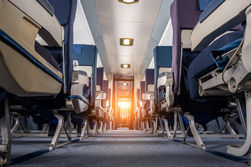 Low angle view of aisle in old commercial aircraft with sun flare