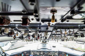 Many switches on aircraft cockpit ceiling in shallow focus
