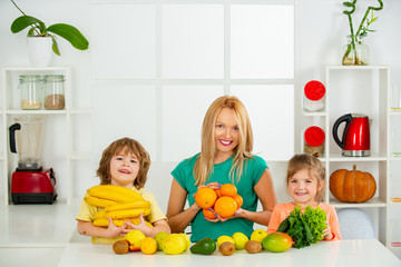 Family mother and child daughter and son blended smoothie with healthy fruits ingredients on...
