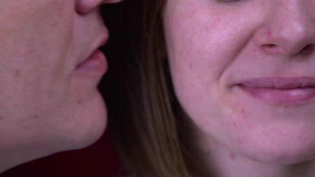 Courtship of love. A man gently kisses a woman on the cheek. Red velvet background