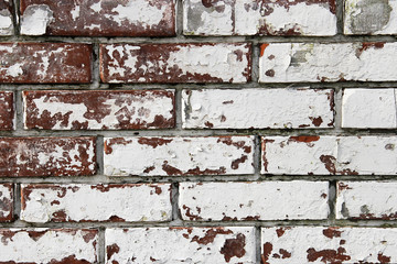 Wall from old and peeling brick, full frame use for the background. Shabby and faded white paint on a brick wall