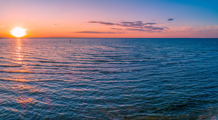 Obraz premium Aerial panorama of sun setting over sea