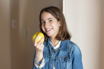 girl looking at the camera with a golden apple in her hand