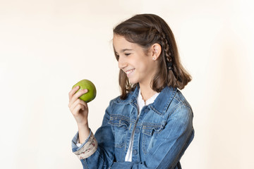 happy girl looking with desire at a green apple