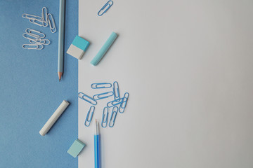Stationery for school and office in pastel colors on a blue and white background, top view, there is space for text. Back to school. Creative school concept.