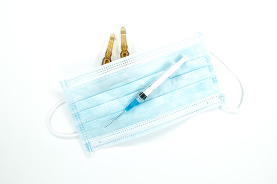 syringe with needle, two ampoules and corona virus mask