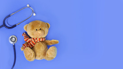 Stuffed teddy bears animal presented as a pediatrician holding a stethoscope with copy space on blue isolated background