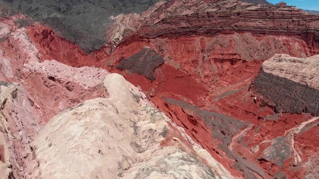 Flying by red mountains near Salta, Argentina. Aerial shot, 4K