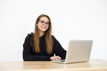 Young girl woman at the table, distance learning for students. Freelancer, distant work, work at home, online education