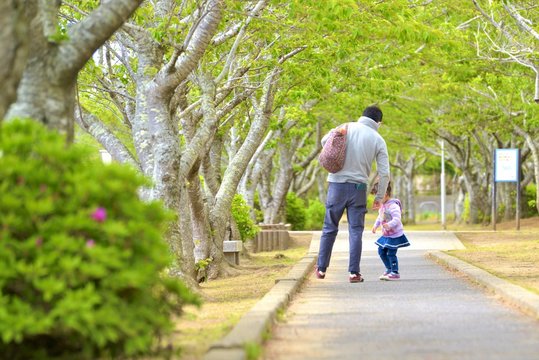 春の公園を散歩する親子
