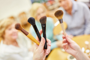 Visagist zeigt Schminkpinsel für das altersgerechte Make-Up im Senioren Schminkkurs