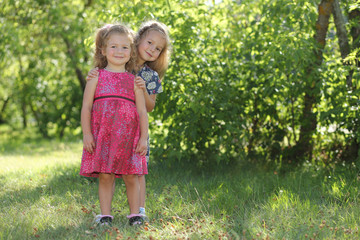 Fototapeta premium cute little sisters having fun in garden.