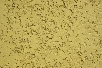 Yellow textured stucco background. colored concrete plaster with bark beetle pattern. decorative plaster texture close up. Facing of the house bark beetle.