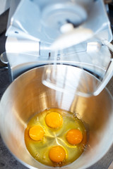Beating eggs with sugar in a kitchen machine. Cream nozzle