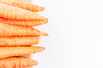 A row of fresh carrots. Healthy nutrition and vitamins. Health and beauty. White background. Space for text.