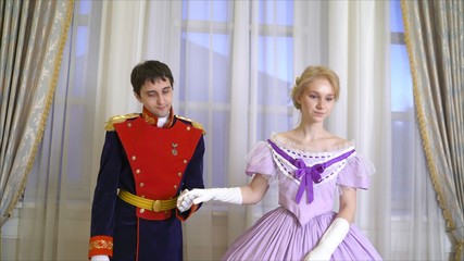 A guy and a girl in white gloves. Cavalier invites a lady to dance. The gentleman kisses the lady's pen.